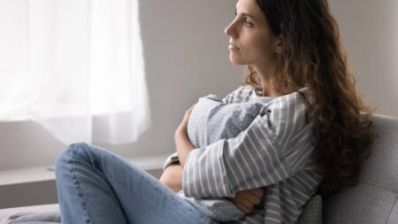 Solitude émotionnelle : pourquoi peut-on se sentir seul même entouré ? femme seule coussin